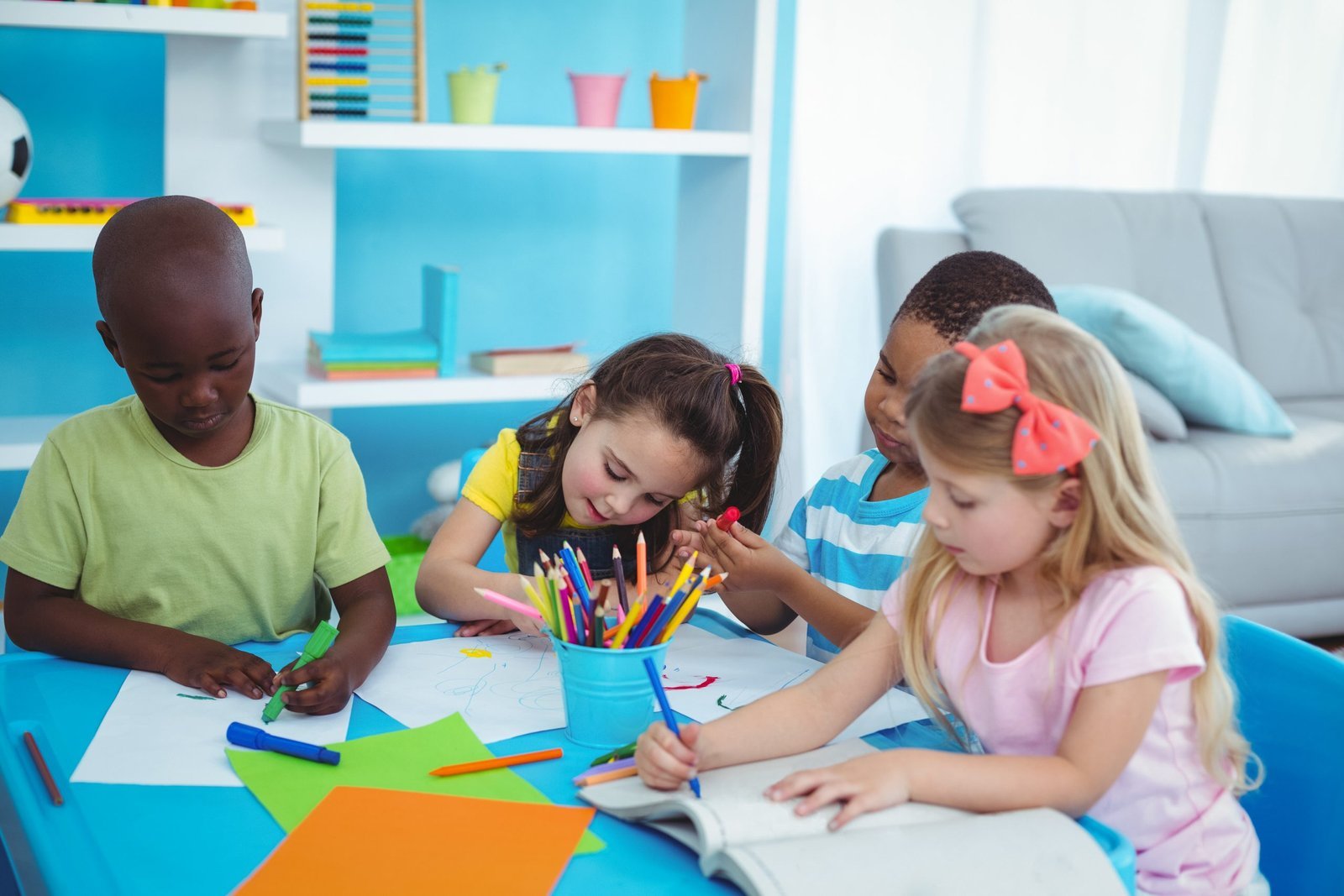 Group of children drawing and colouring together at a table